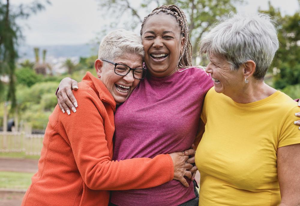 three woman laughing and hugging