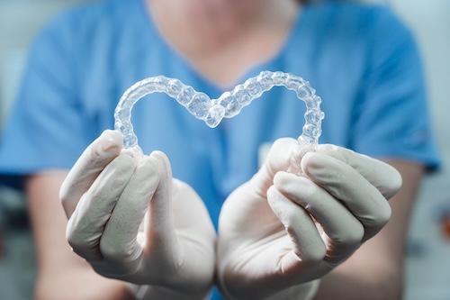 two invlisalign aligners being held by dentist