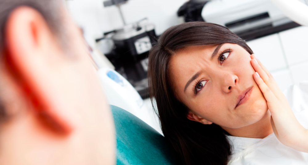 woman holding jaw from tooth pain