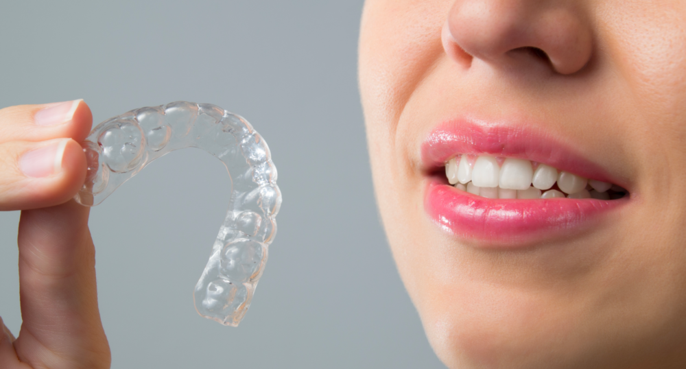 woman holding invisalign clear aligners in irvine