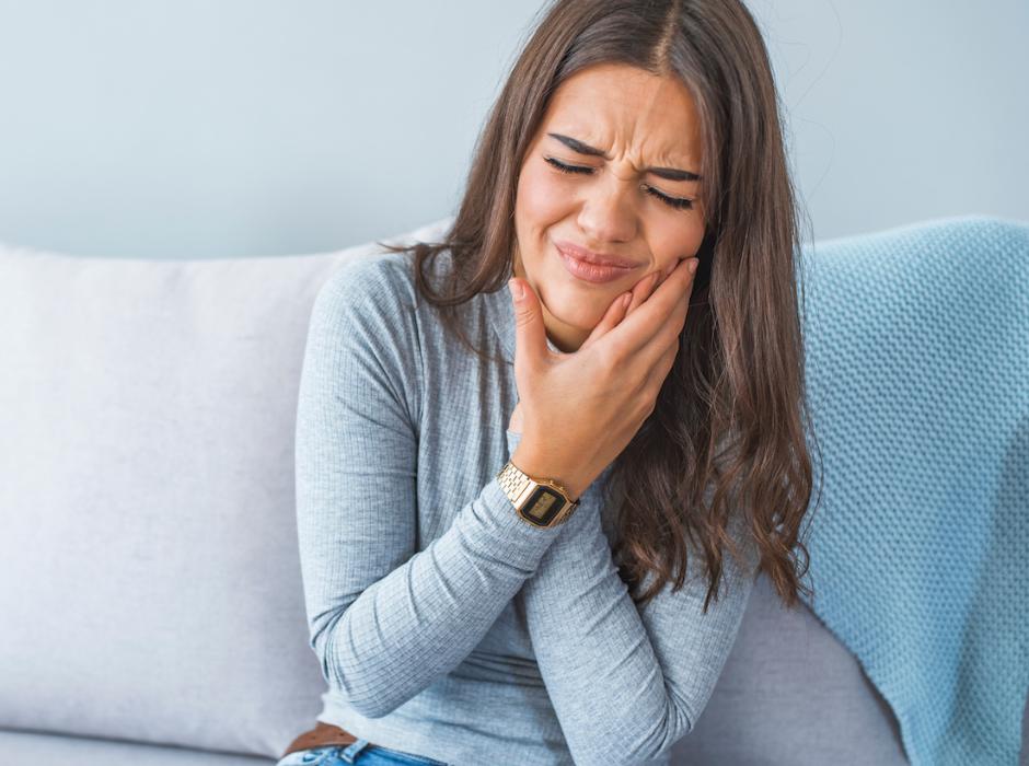 woman holding jaw from tmj pain