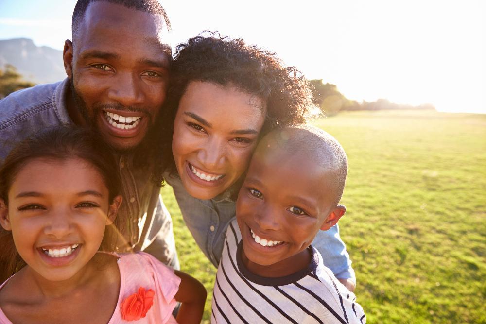family of four smiling in irvine park
