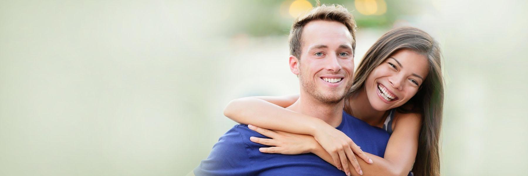 woman hugging her boyfriend's shoulders, both smiling