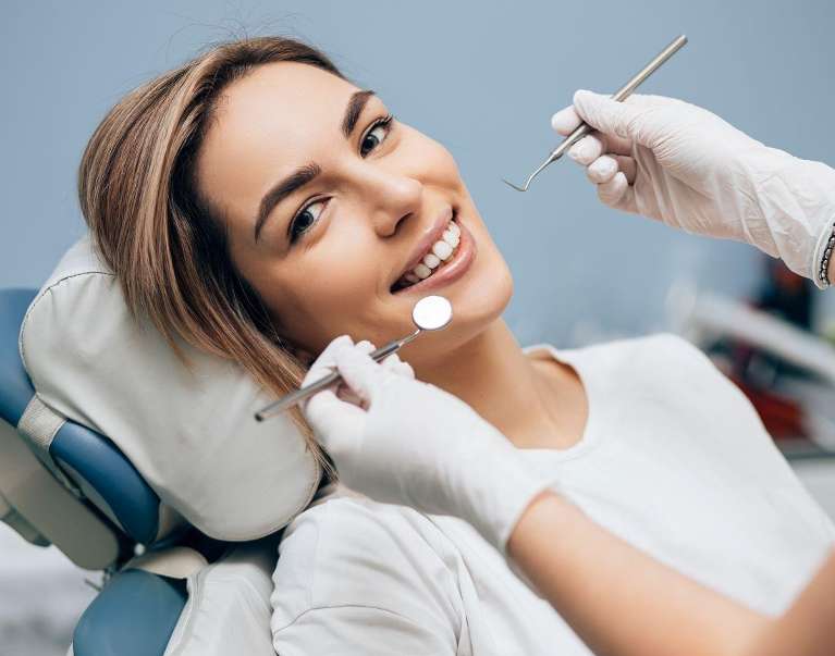 woman smiling in dental chair during a dental cleaning in irvine