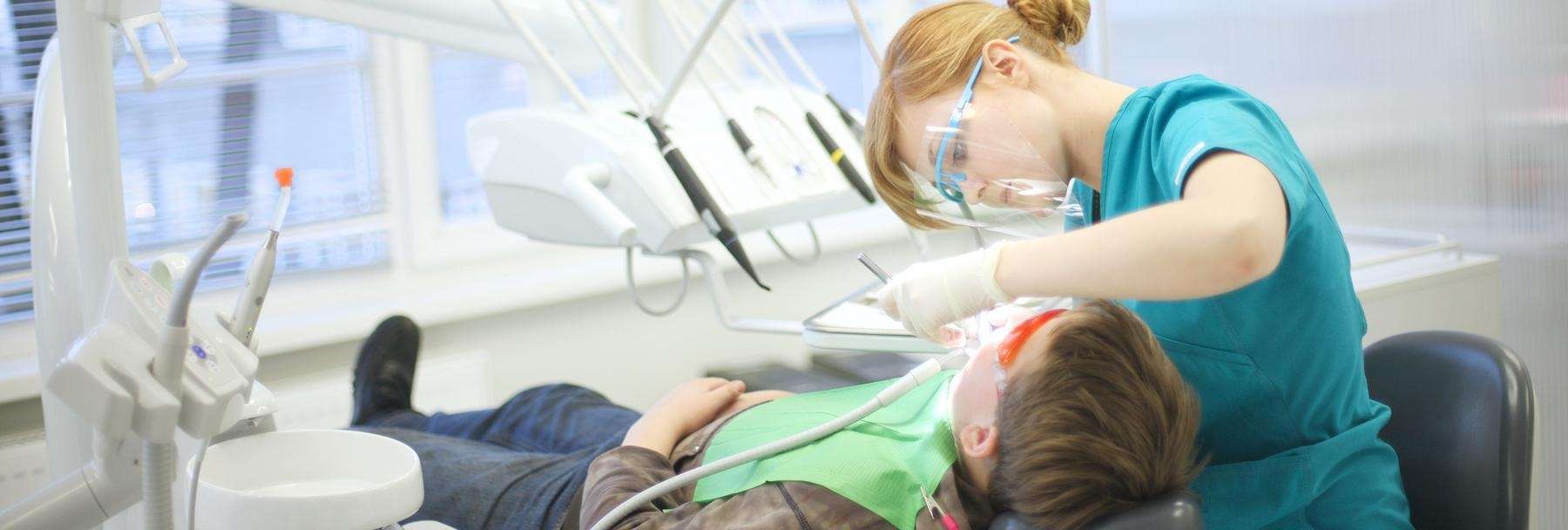 dentist working on patient in dental chair