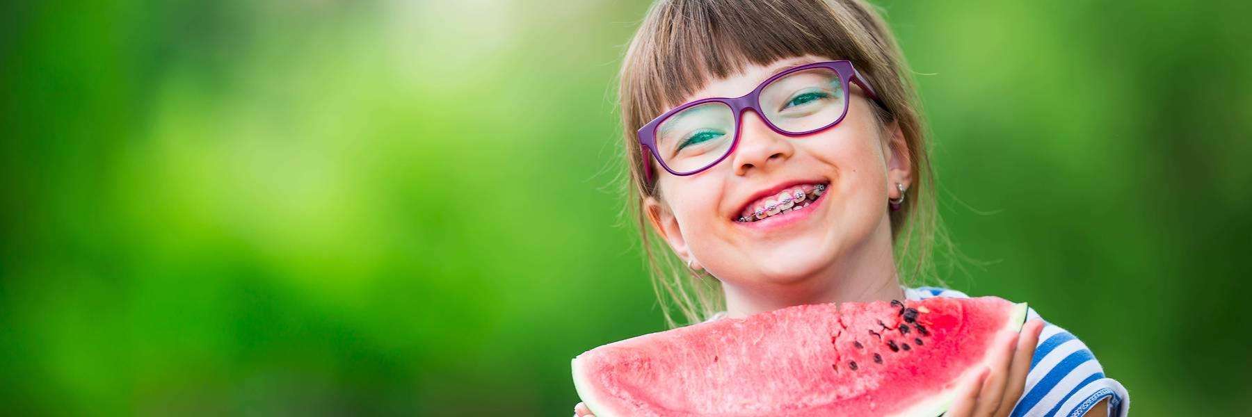 young girl with braces eating watermelon in irvine