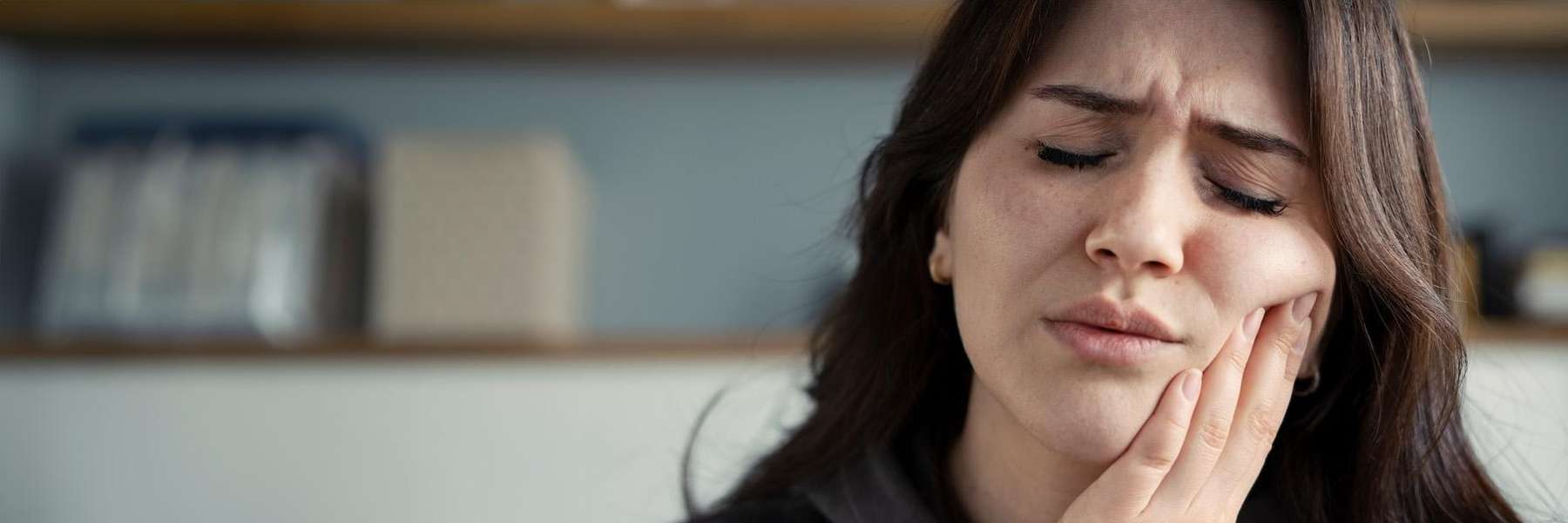 woman holding jaw from TMJ pain